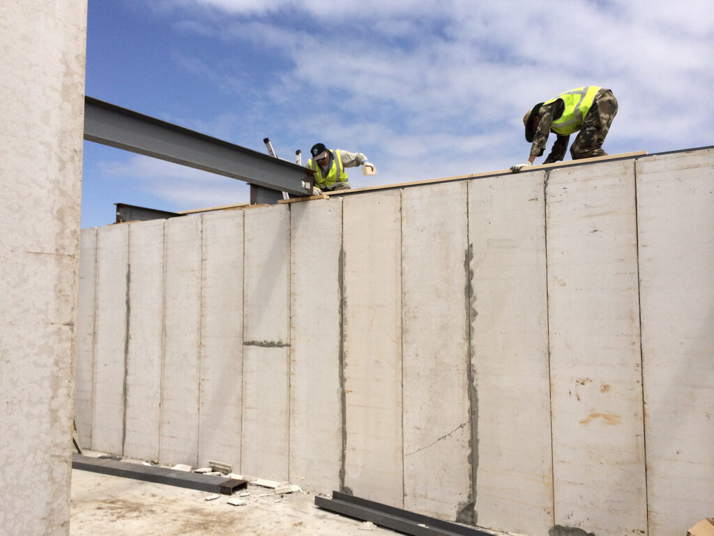 Construction men working on building wall